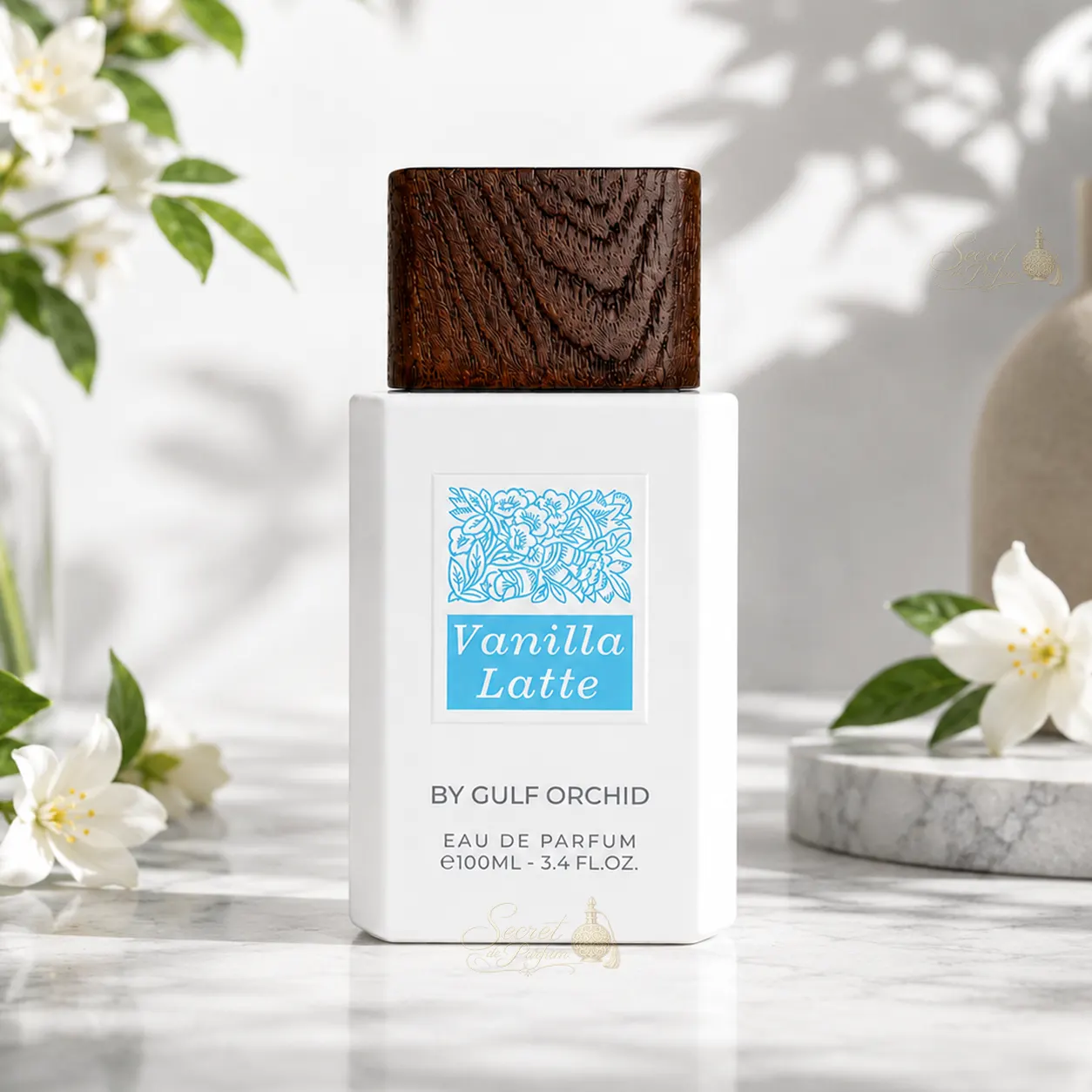 Vanilla Latte – Gulf Orchid | Parfum gourmand vanille latte 100 ml 4 Flacon Vanilla Latte de Gulf Orchid dans un décor floral lumineux mettant en valeur son univers gourmand, vanillé et ambré.