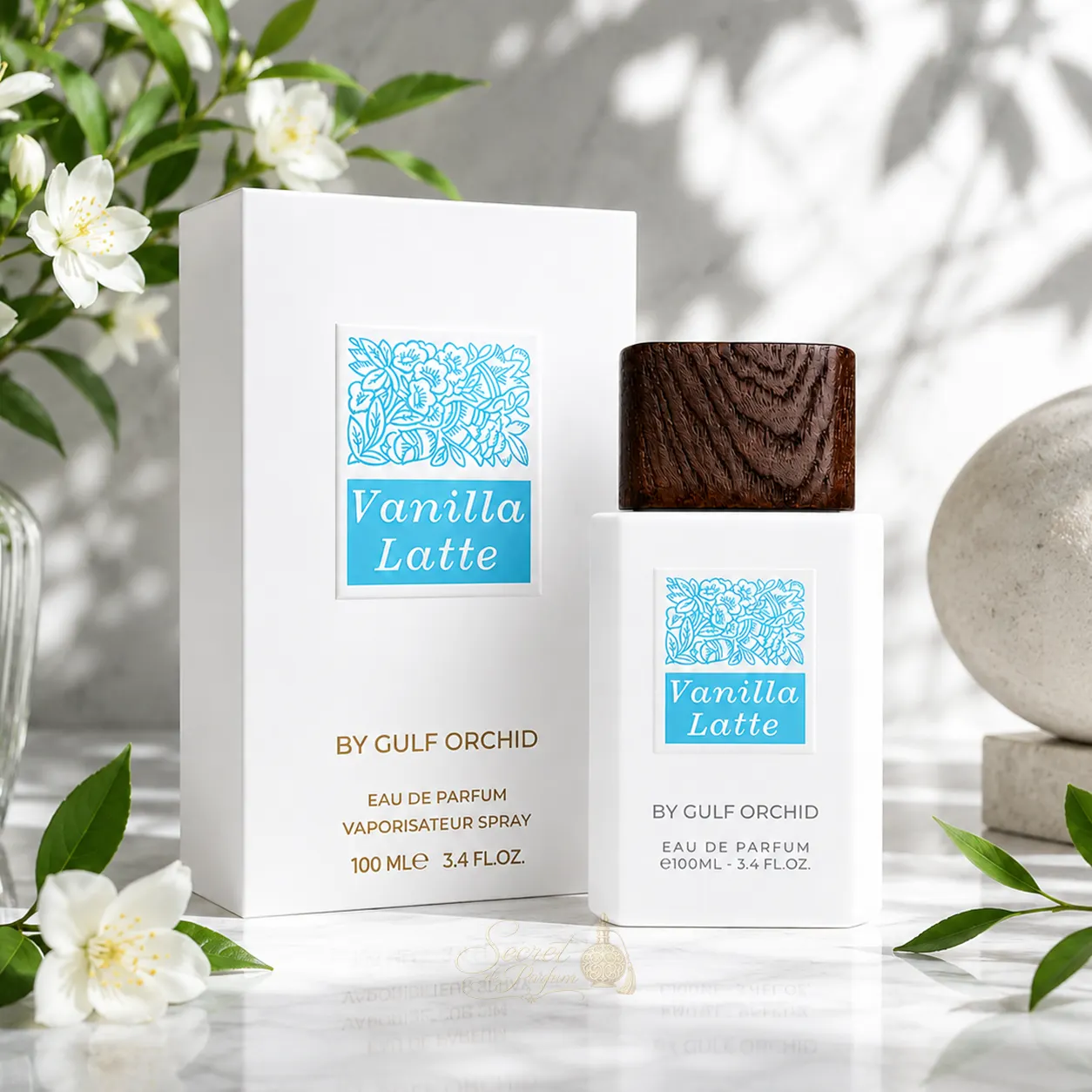 Vanilla Latte – Gulf Orchid | Parfum gourmand vanille latte 100 ml 3 Boîte et flacon Vanilla Latte de Gulf Orchid dans un décor floral raffiné, parfum gourmand aux accords de vanille, caramel, miel et musc.